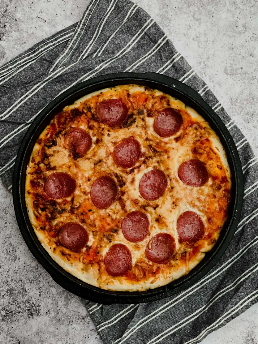 Pizza mit Salami und goldbraun überbackenem Käse